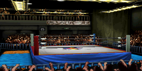 Screenshot of AKI Hall, equally focused
on the ring area, as well as one of the balconies. The balcony area features a
few fans, guardrails, and a hanging cloth sign with Japanese text. The overhead
ring lighting setup is visible in this screenshot. The ring has a mat design
featuring the AKI Corporation logo. Most of the canvas is gray, but there is a border
section containing a yellow stripe and larger red area. The ring skirt is blue,
as are the outside mats. The outside corners (only one of which is clearly visible
in this screenshot) are parquet wood floor.